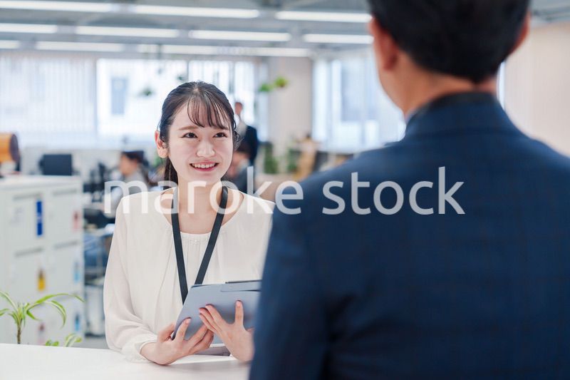 窓口で来客の対応をする女性スタッフ