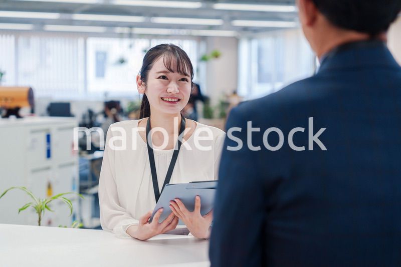 窓口で来客の対応をする女性スタッフ