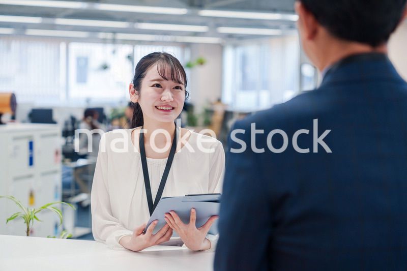 窓口で来客の対応をする女性スタッフ