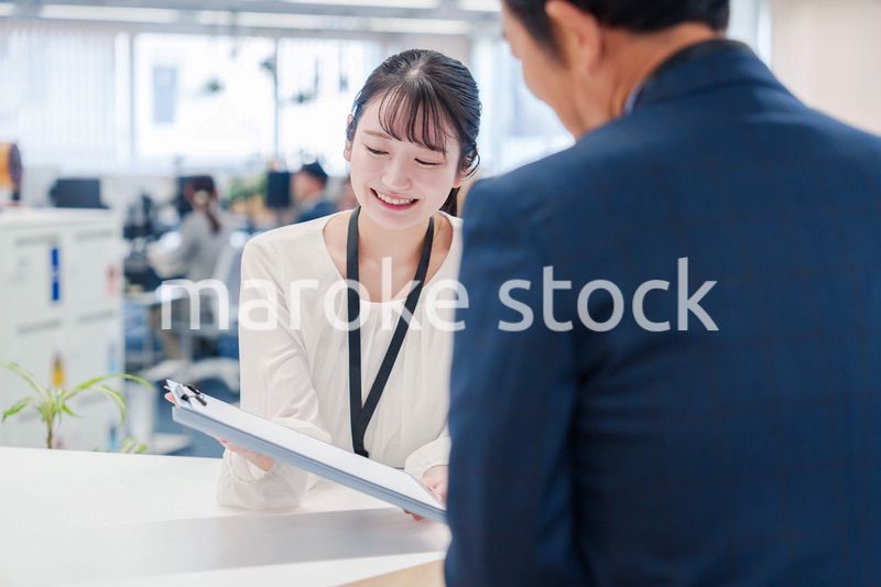 窓口で来客の対応をする女性スタッフ