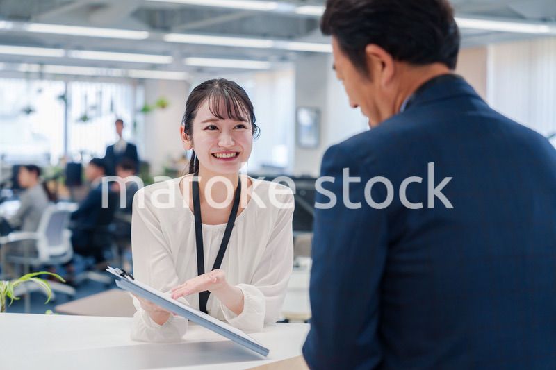 窓口で来客の対応をする女性スタッフ