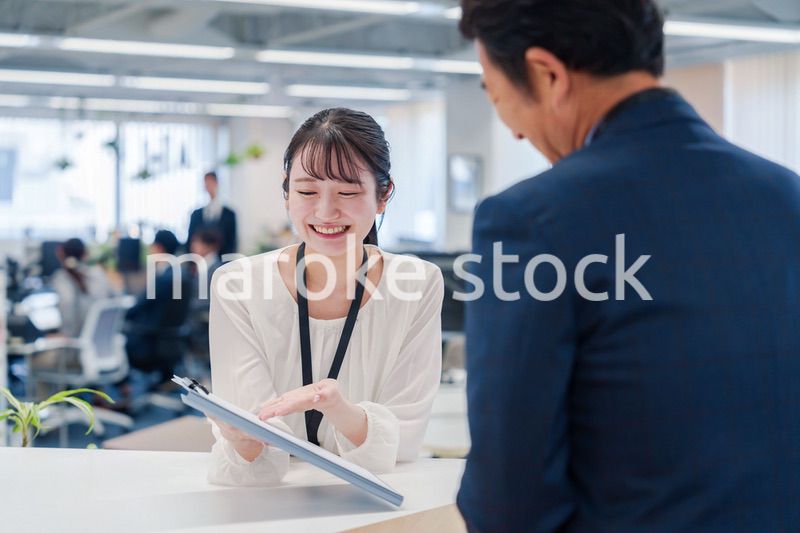 窓口で来客の対応をする女性スタッフ