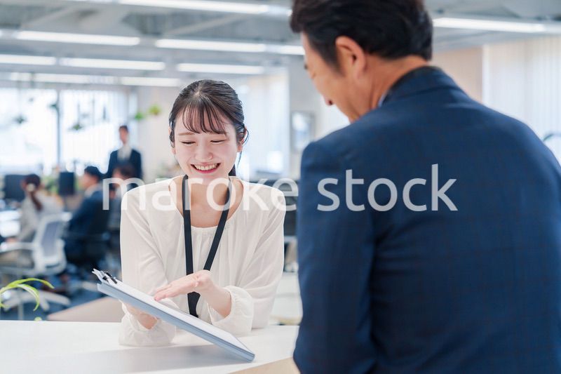 窓口で来客の対応をする女性スタッフ