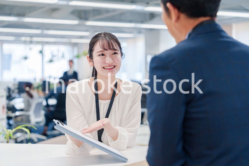 窓口で来客の対応をする女性スタッフ