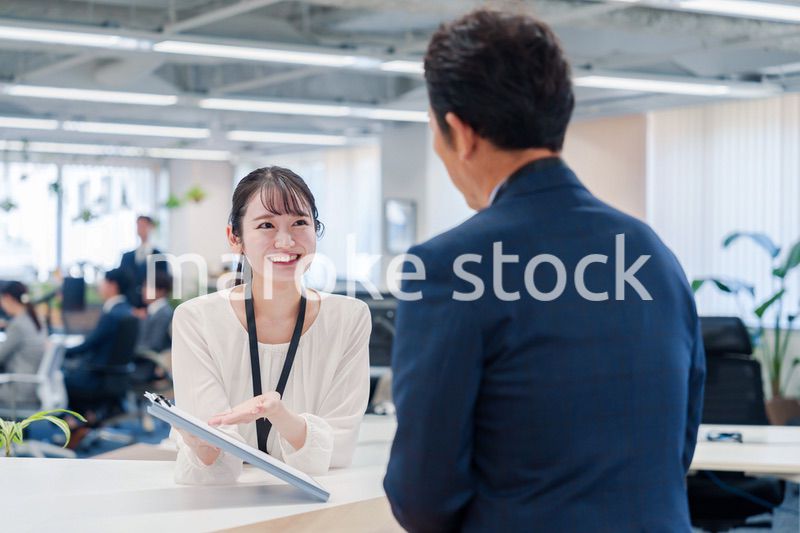 窓口で来客の対応をする女性スタッフ
