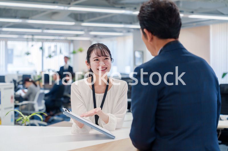 窓口で来客の対応をする女性スタッフ