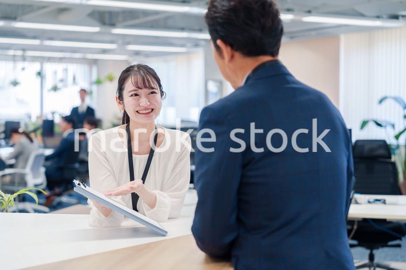 窓口で来客の対応をする女性スタッフ
