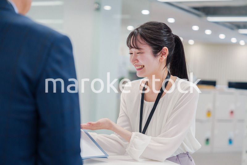 窓口で来客の対応をする女性スタッフ