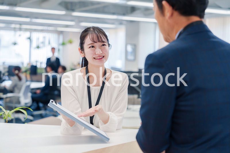窓口で来客の対応をする女性スタッフ
