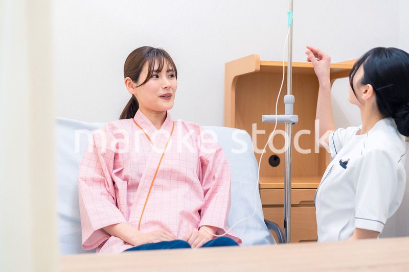 入院中の患者と話す医療従事者の女性