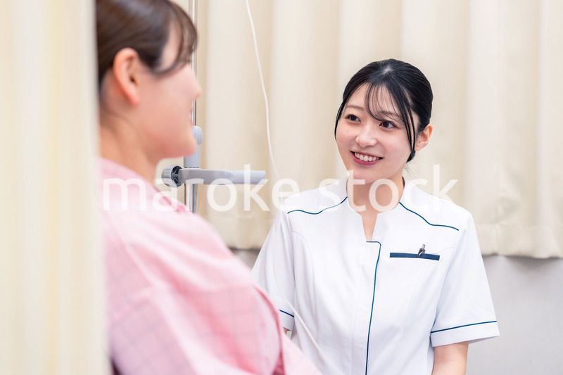 入院中の患者と話す医療従事者の女性