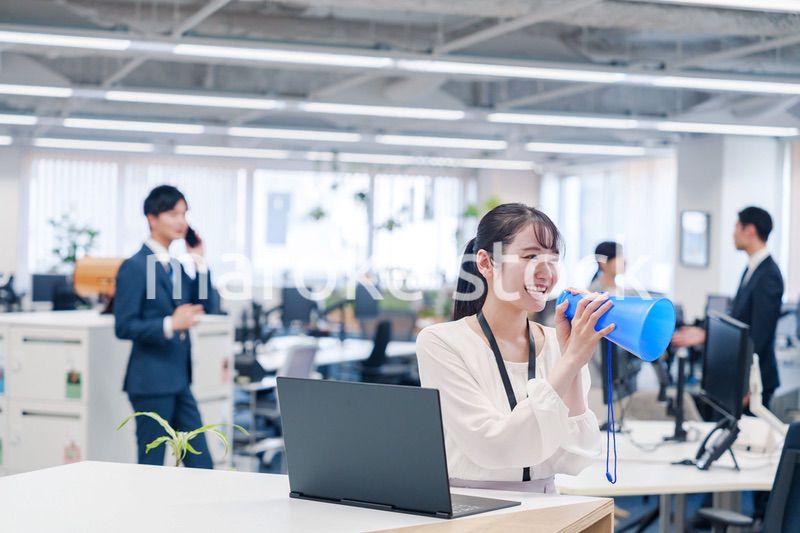 オフィスでメガホンを使って話す若い女性