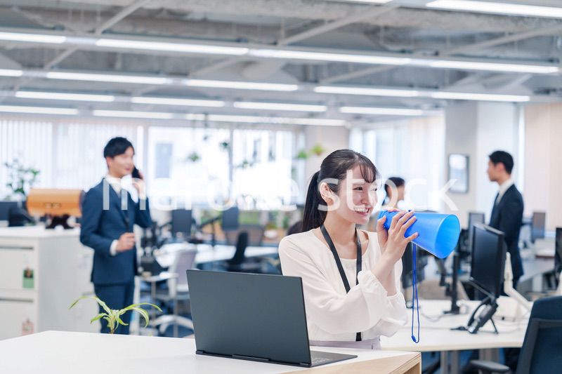 オフィスでメガホンを使って話す若い女性