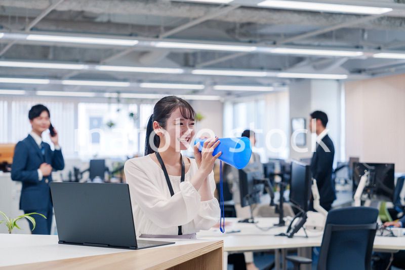 オフィスでメガホンを使って話す若い女性