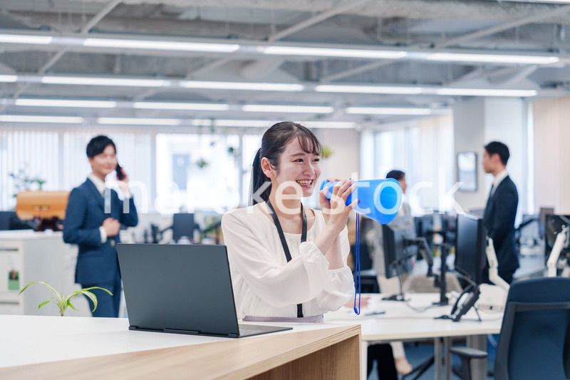 オフィスでメガホンを使って話す若い女性