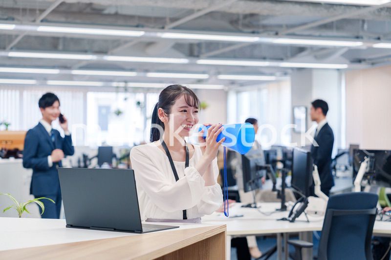 オフィスでメガホンを使って話す若い女性