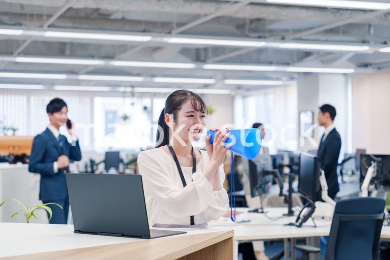 オフィスでメガホンを使って話す若い女性