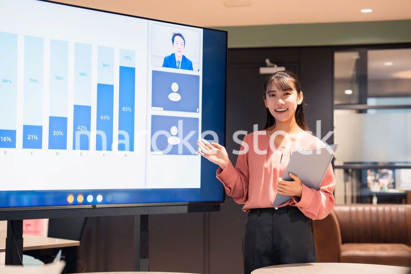 オフィスでリモートメンバーとの会議をする女性スタッフ