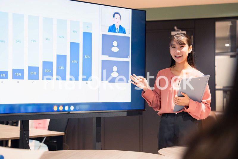 オフィスでリモートメンバーとの会議をする女性スタッフ