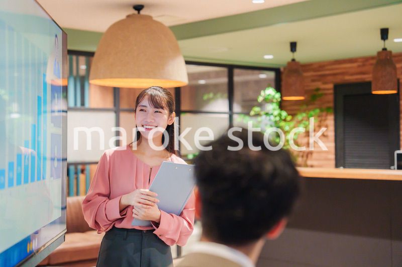 モダンオフィスでプレゼンをする若い女性