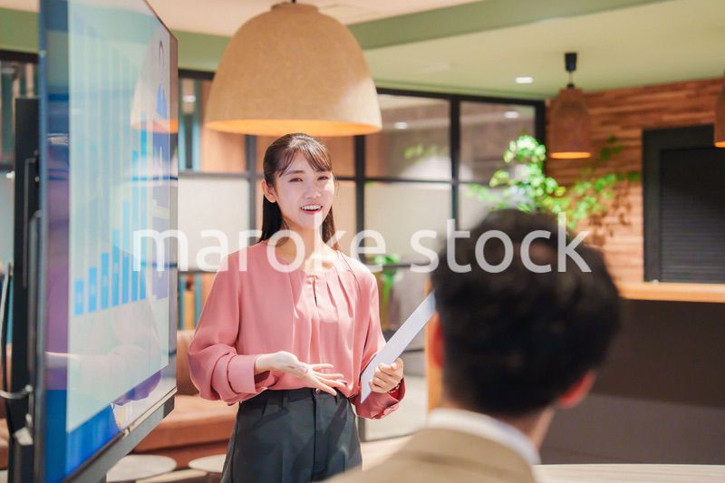 モダンオフィスでプレゼンをする若い女性