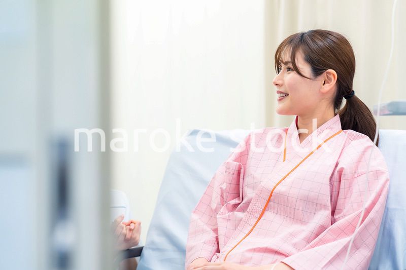 病院に入院している院内着を着た若い女性