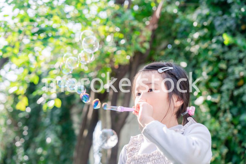 シャボン玉をして遊ぶ小さな女の子