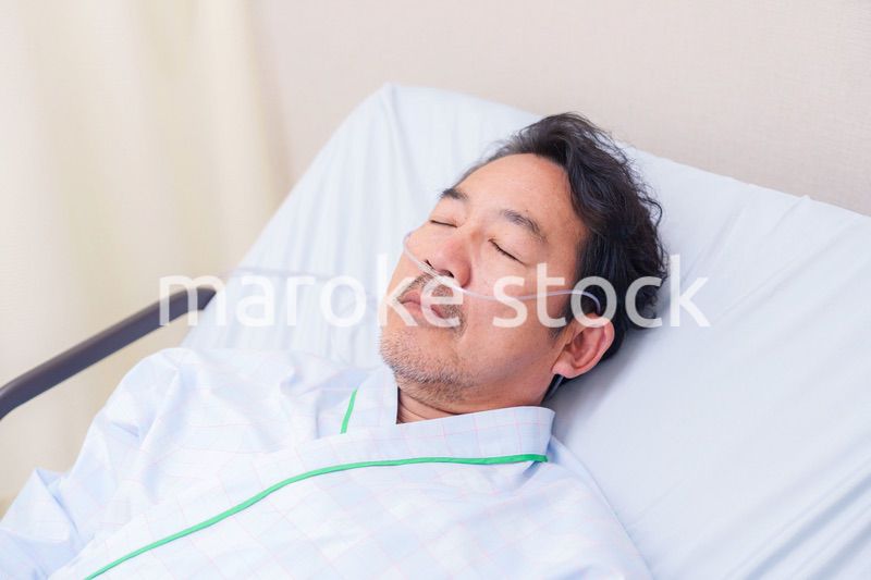 鼻にチューブを装着した入院患者の高齢男性