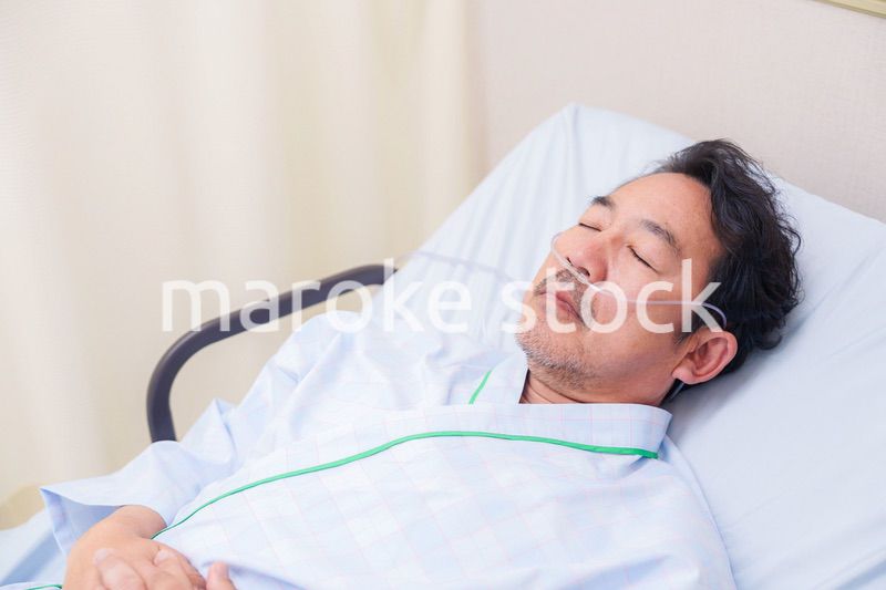 鼻にチューブを装着した入院患者の高齢男性