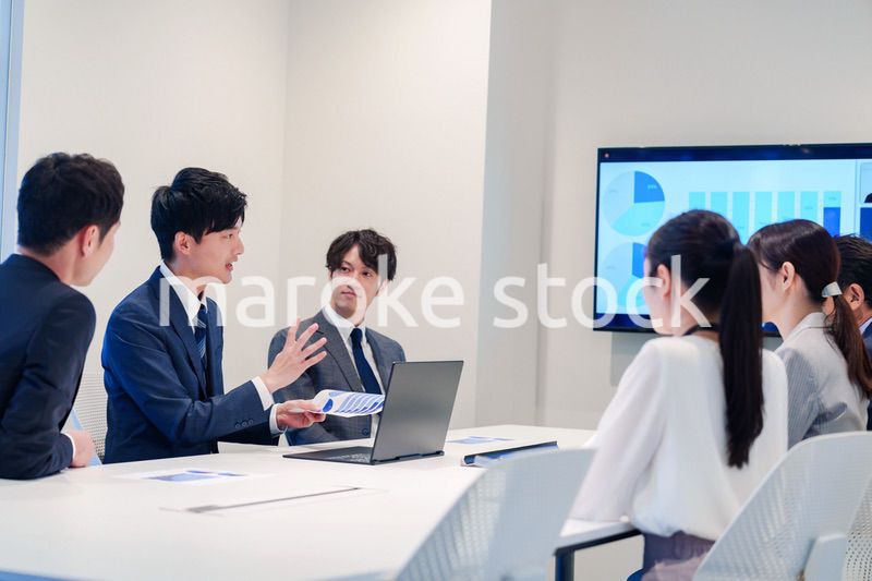 スーツを着て会議で話す若い男性
