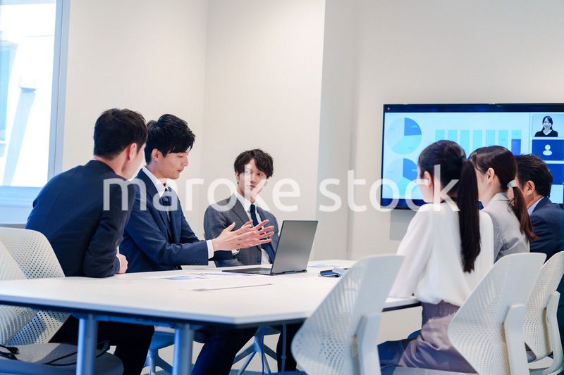 スーツを着て会議で話す若い男性