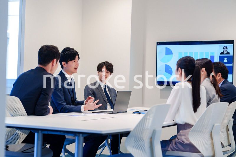 スーツを着て会議で話す若い男性