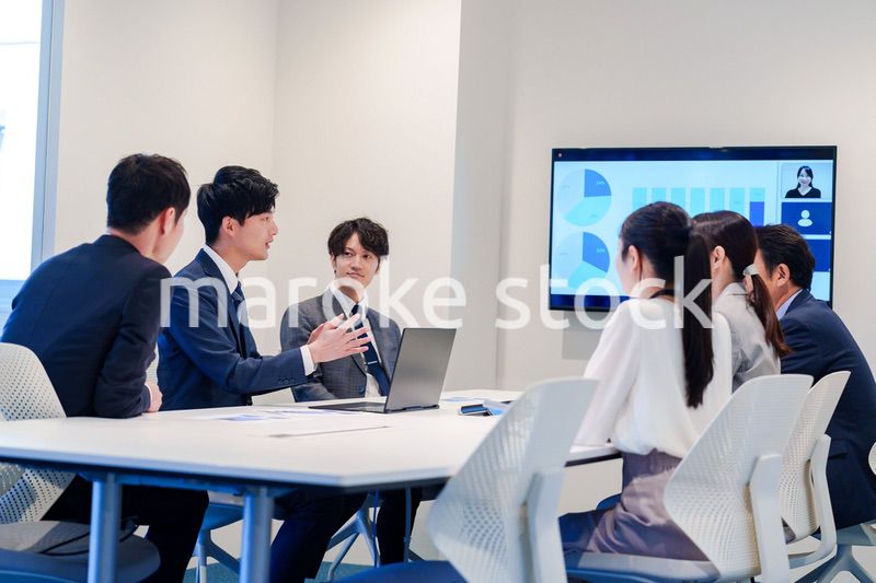 スーツを着て会議で話す若い男性