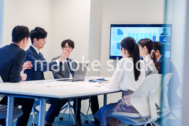 スーツを着て会議で話す若い男性