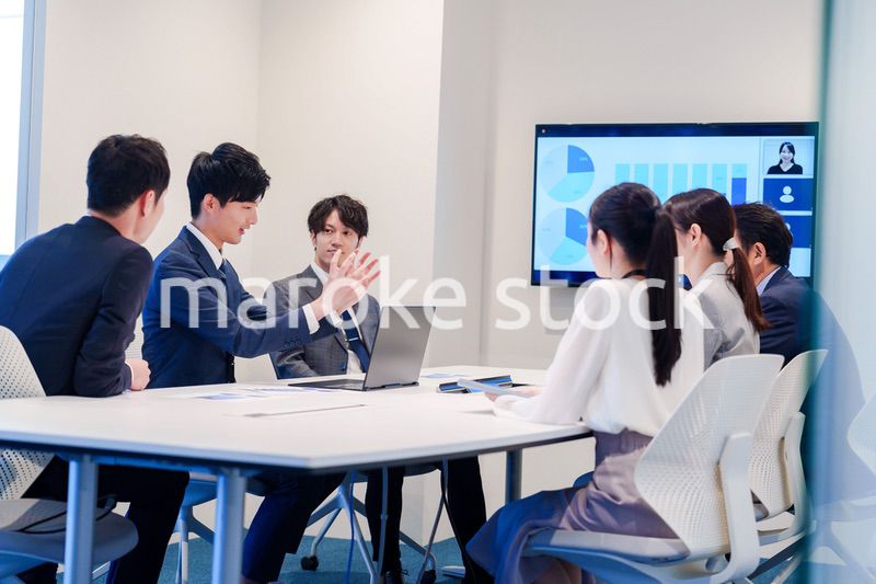 スーツを着て会議で話す若い男性