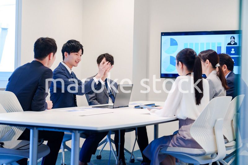 スーツを着て会議で話す若い男性