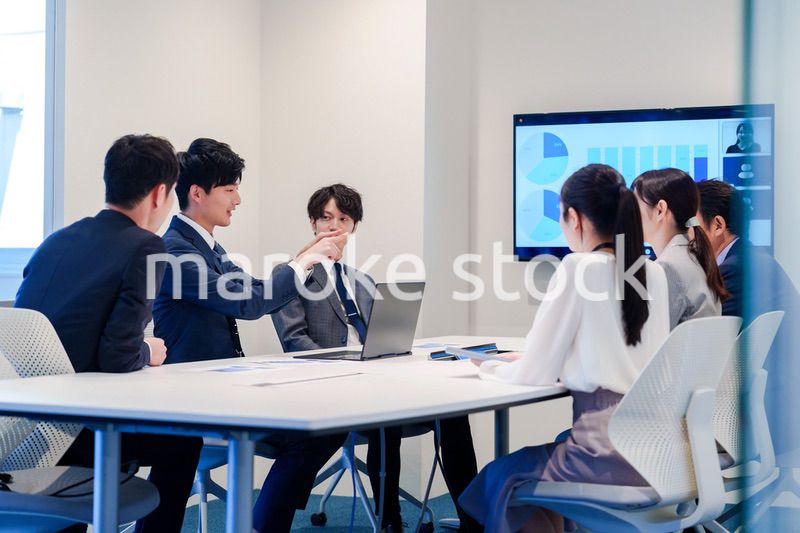 スーツを着て会議で話す若い男性