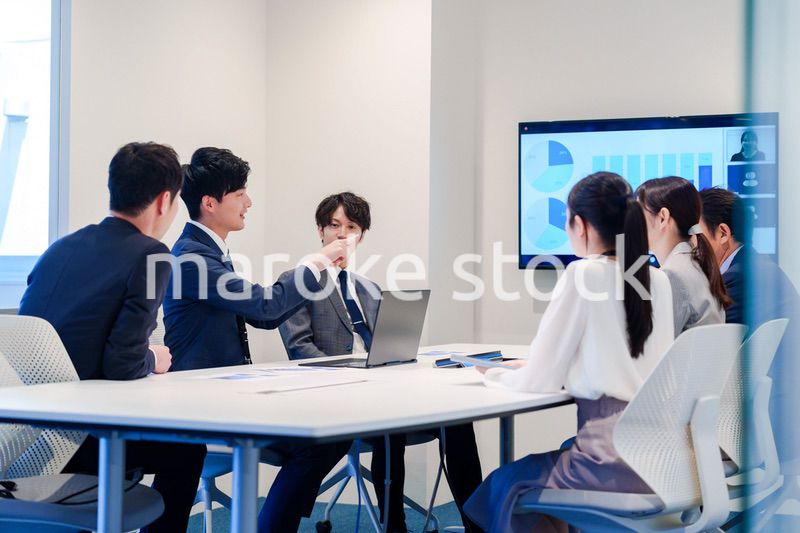 スーツを着て会議で話す若い男性