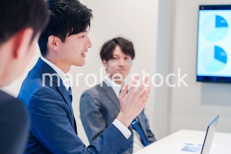 ミーティングで発言をする若い男性ビジネスマン