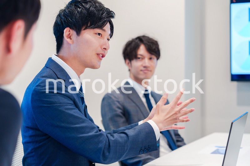 ミーティングで発言をする若い男性ビジネスマン