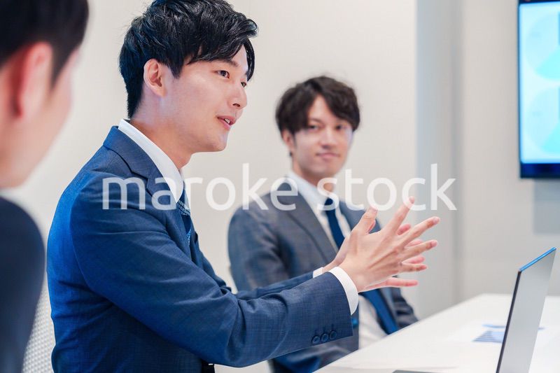 ミーティングで発言をする若い男性ビジネスマン