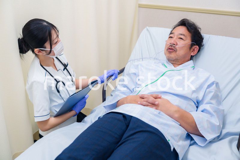 病棟で入院患者のケアをする医療従事者の女性