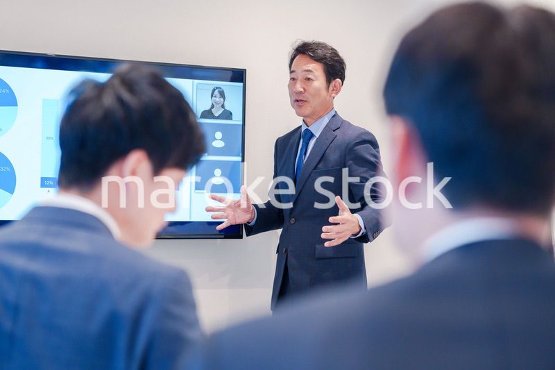 オフィスでのリモート会議で発言をするシニアのビジネスマン