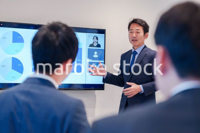 オフィスでのリモート会議で発言をするシニアのビジネスマン