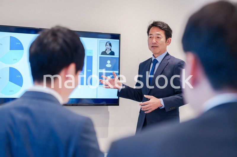 オフィスでのリモート会議で発言をするシニアのビジネスマン