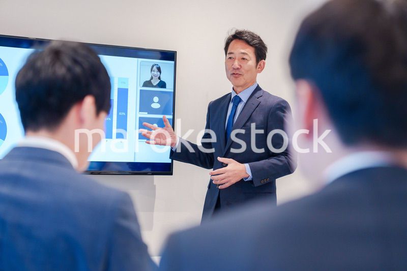 オフィスでのリモート会議で発言をするシニアのビジネスマン