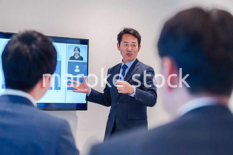 オフィスでのリモート会議で発言をするシニアのビジネスマン