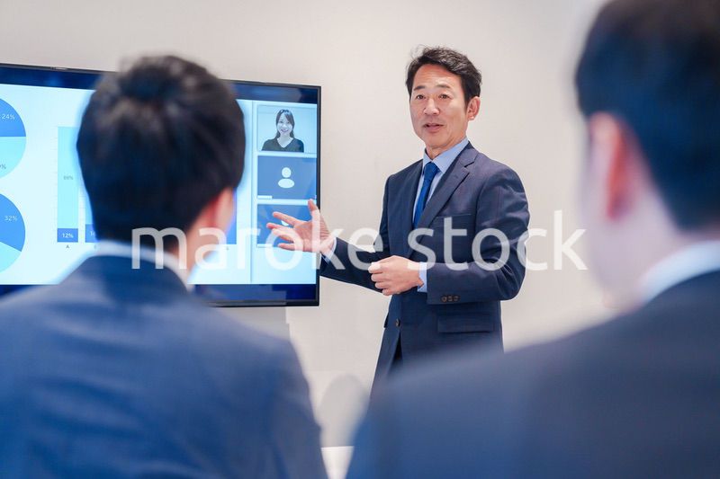 オフィスでのリモート会議で発言をするシニアのビジネスマン