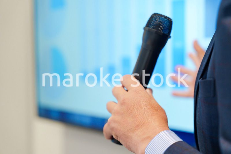 データを示しながらプレゼンをするビジネスマン