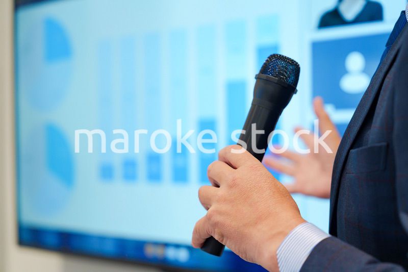 データを示しながらプレゼンをするビジネスマン